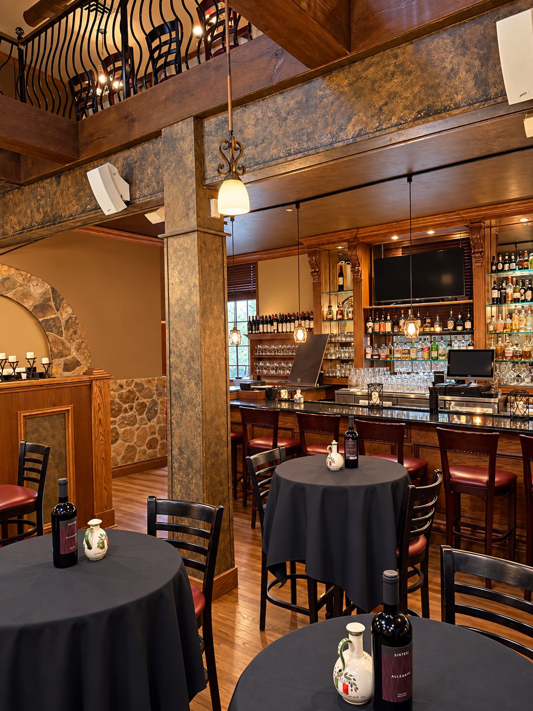 The main bar with a wrought-iron balcony above and stone columns